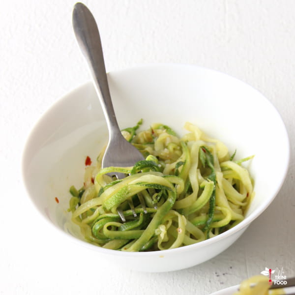 zucchini noodles with fork on white background