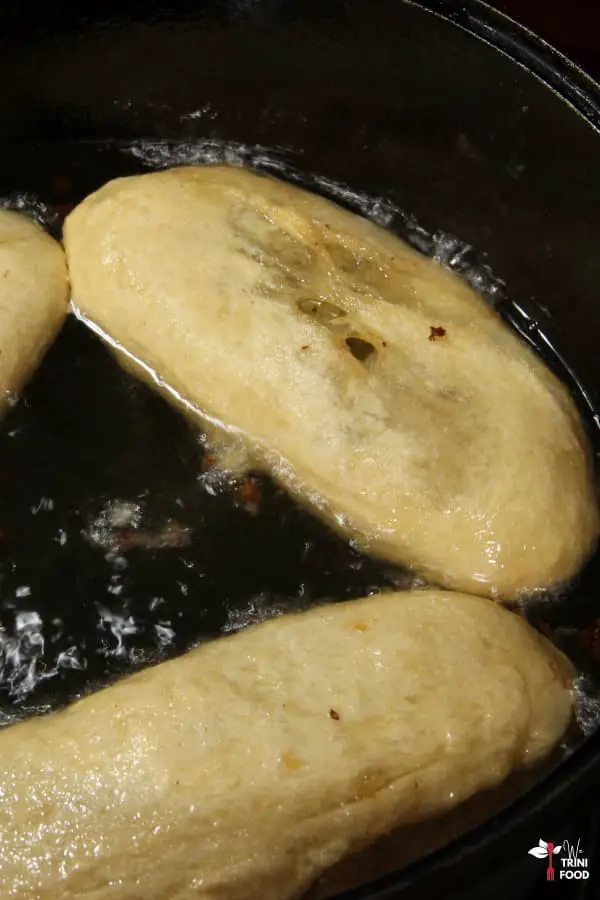 frying aloo pies in cast iron pot in oil