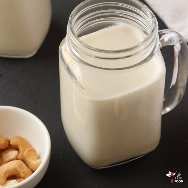 cashew milk in mason jar with cashews in a bowl on the side