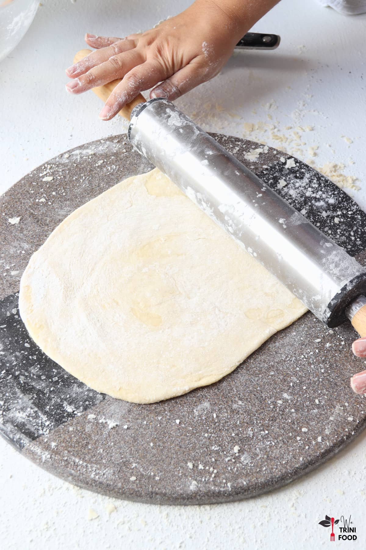 rolling out buss up shut dough ball for cooking with rolling pin