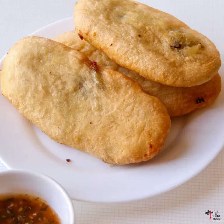 three aloo pies on a white plate with a small bowl of tamarind sauce on the left side
