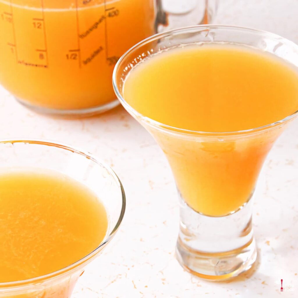 passion fruit juice in glasses with a jug of juice in the background