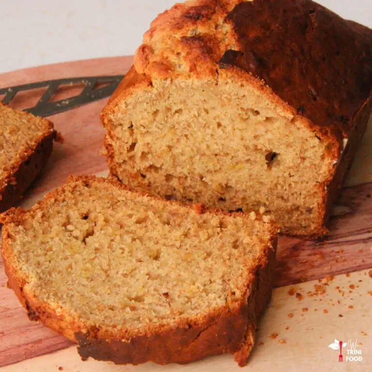 slicing a baked banana bread on a wooden cutting board