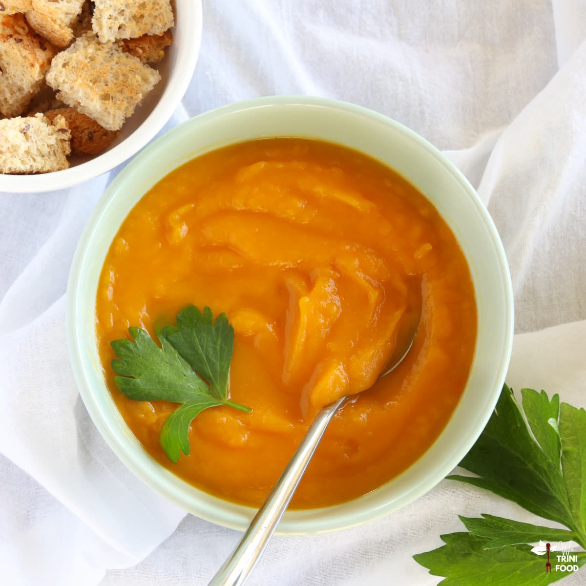 butternut squash sweet potato soup in bowl with croutons on the side