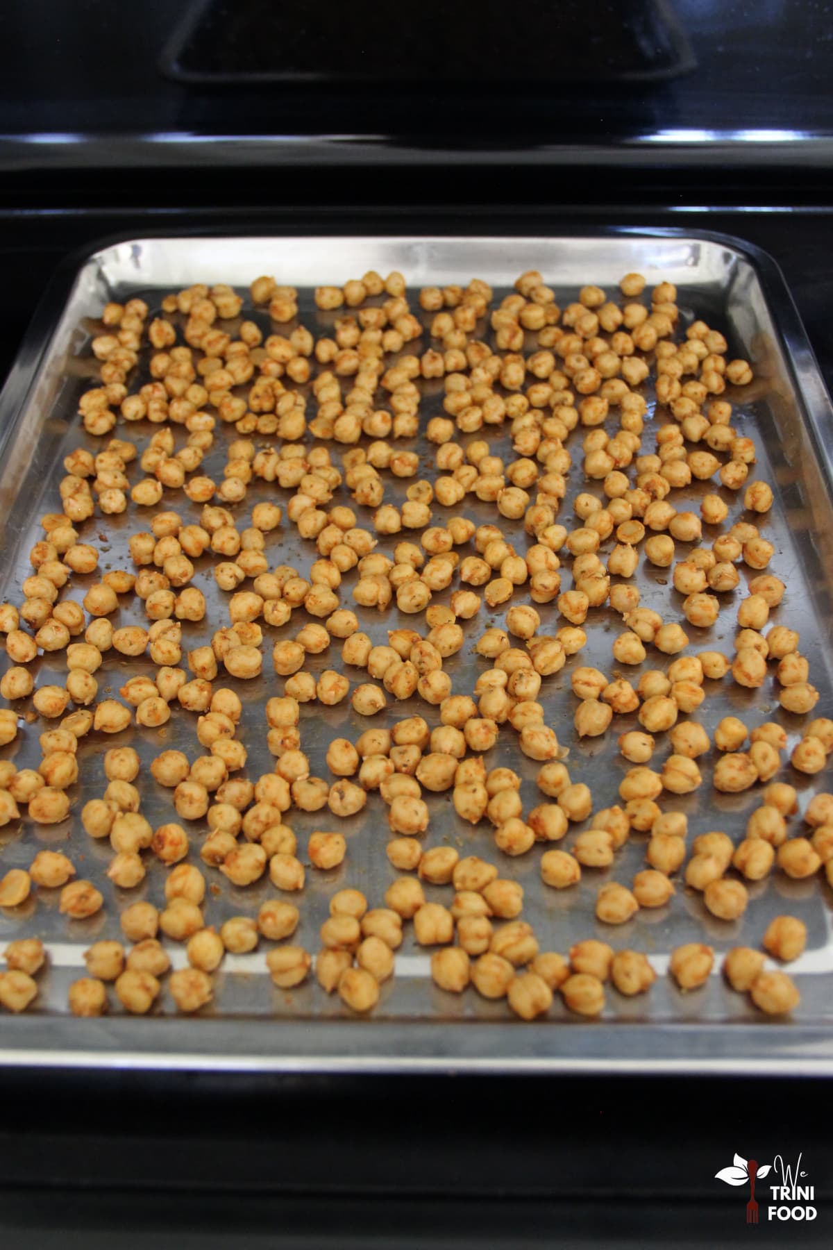 seasoned chickpeas in baking tray before roasting