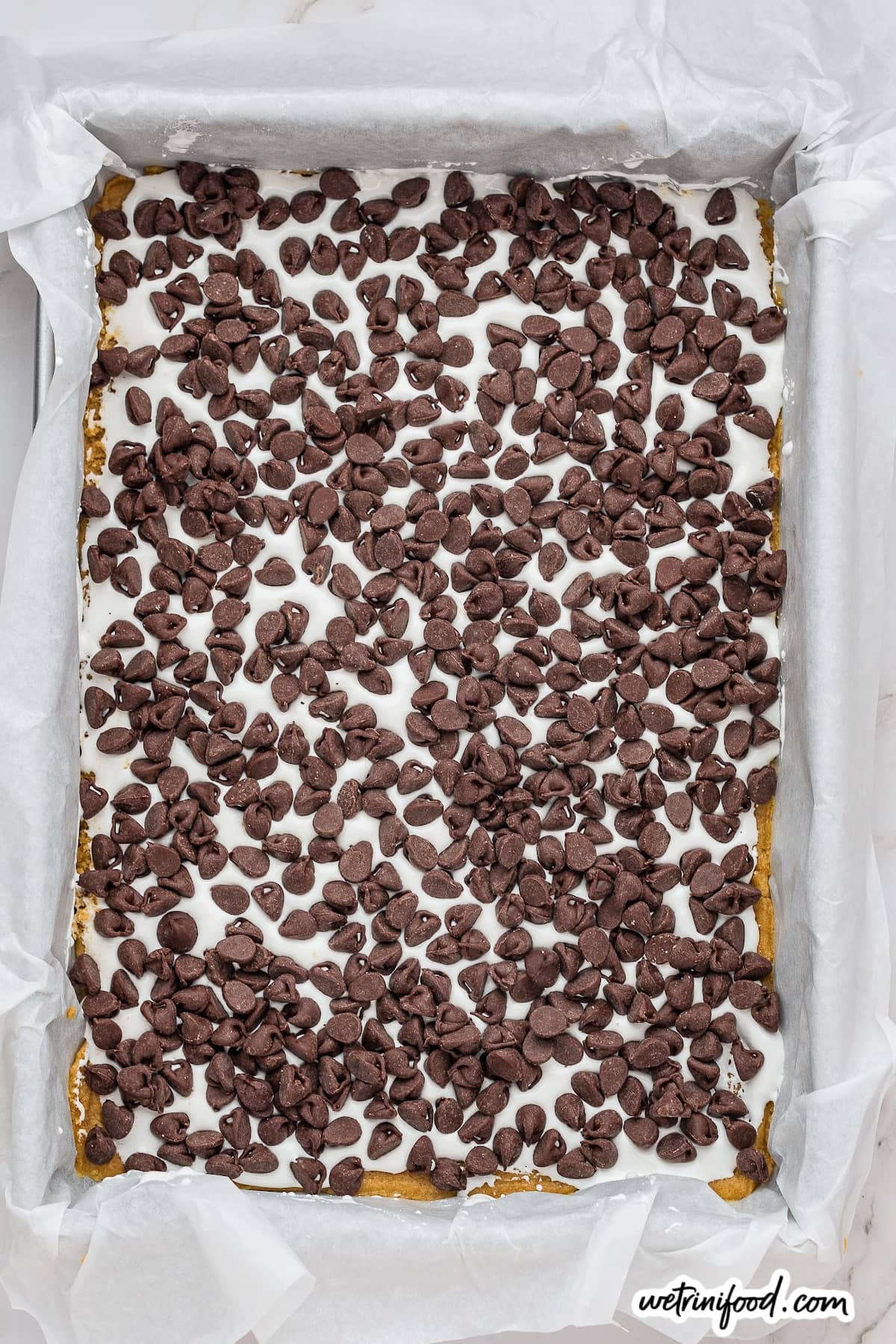 layer of chocolate chips on marshmallow fluff for smores bars