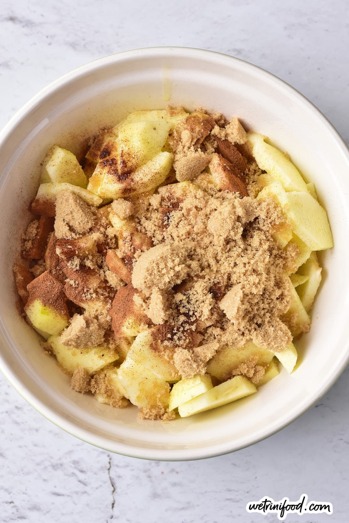 dry ingredients on apple pieces in a bowl