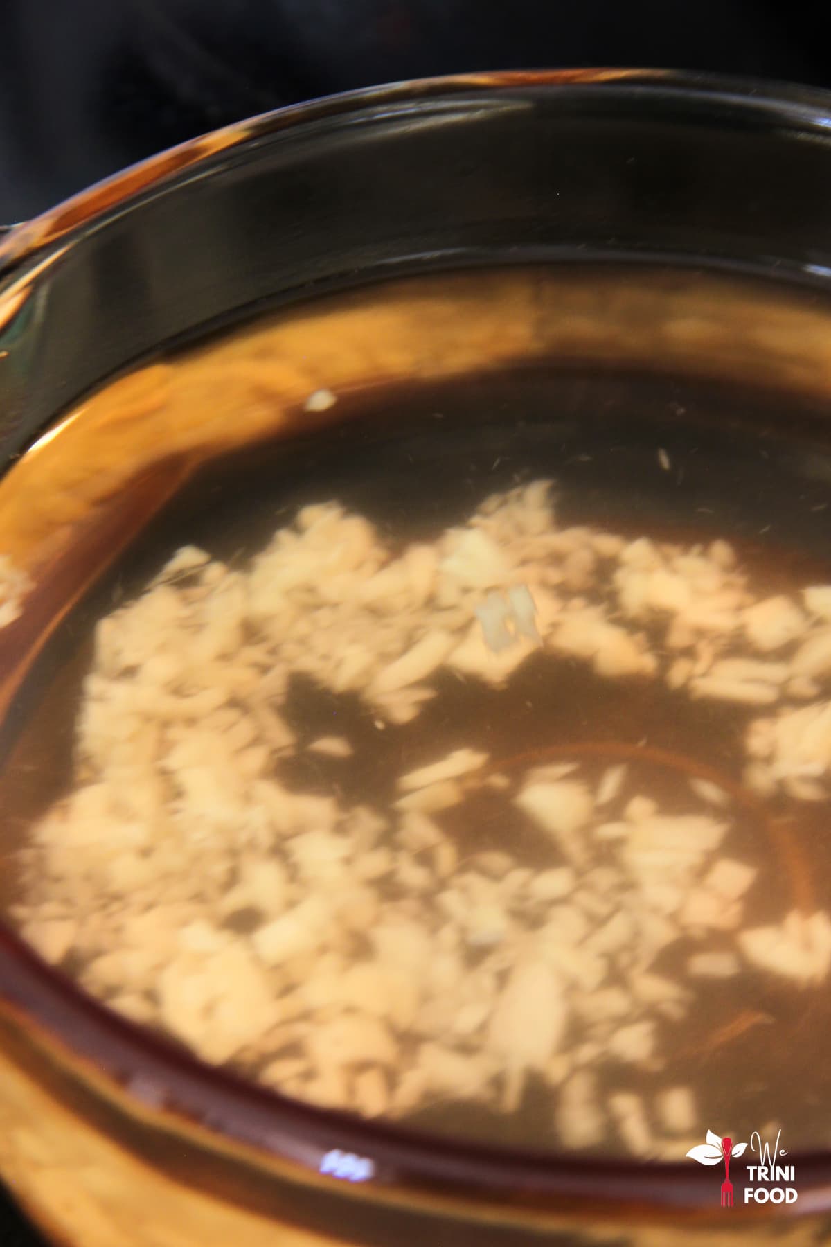 ginger and water in a glass pot on the stove