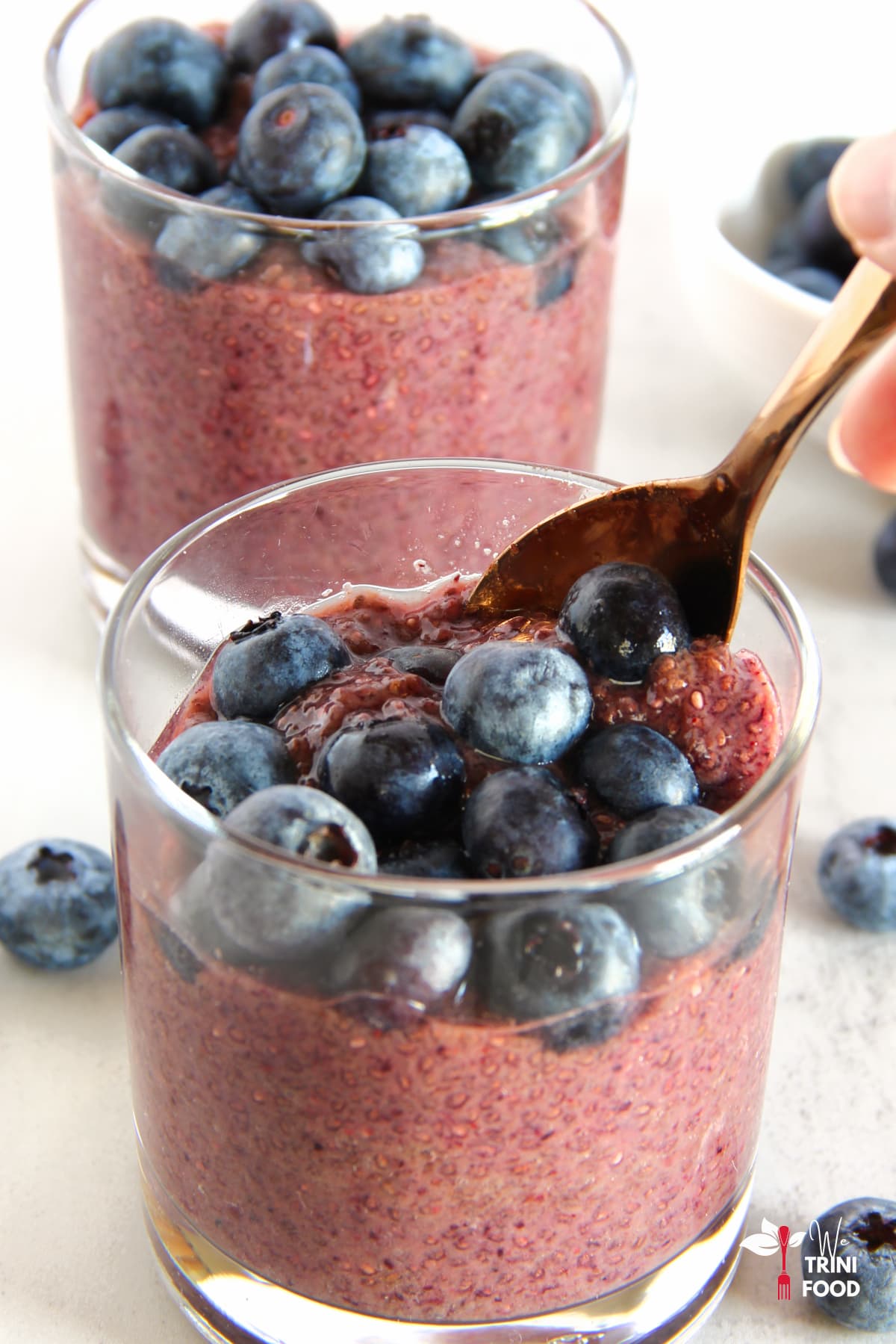 spooning some blueberries and blueberry chia pudding