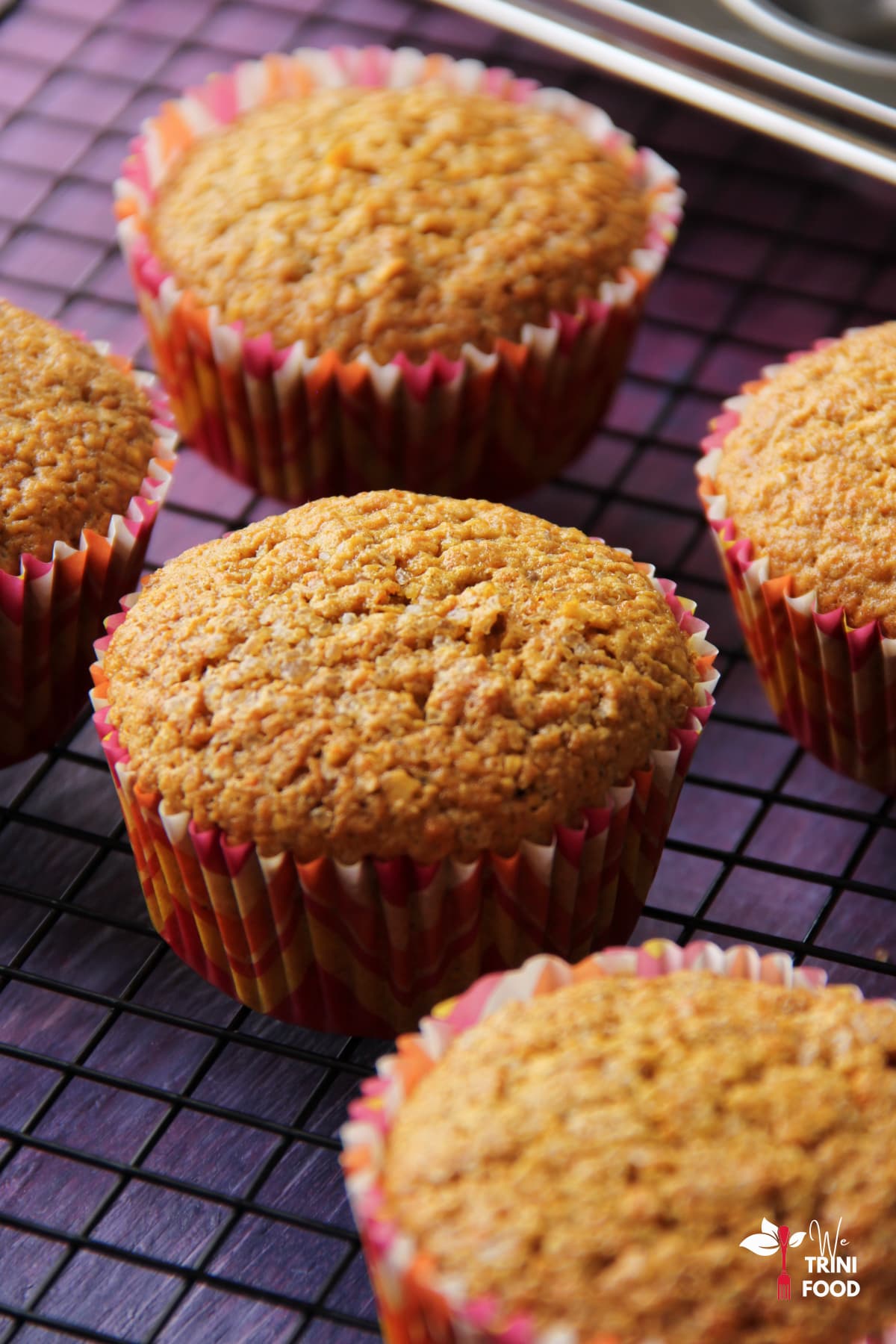 Gluten free carrot oatmeal muffins on a cooling rack after baking