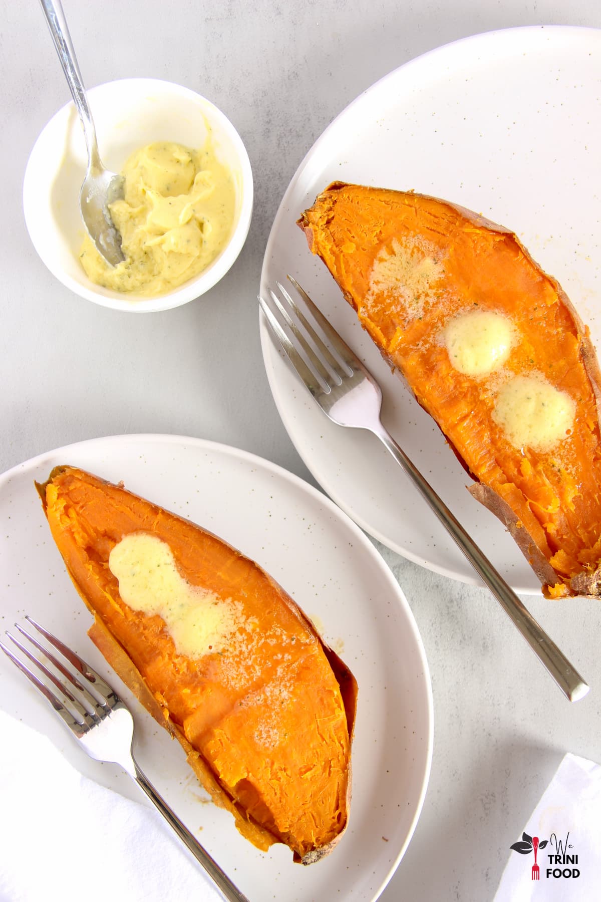 Plated oven baked sweet potatoes with butter on top