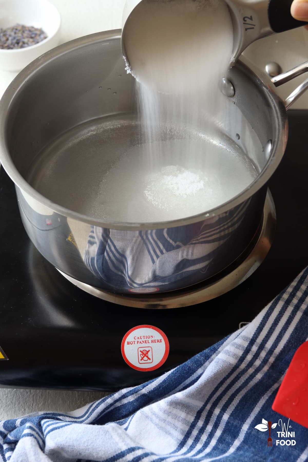 Adding sugar to water for lavender syrup