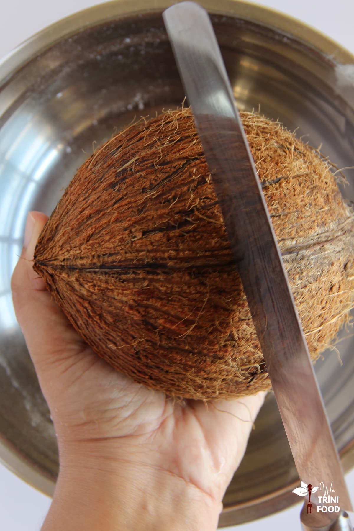 Cracking coconut for Trinidad coconut bake recipe