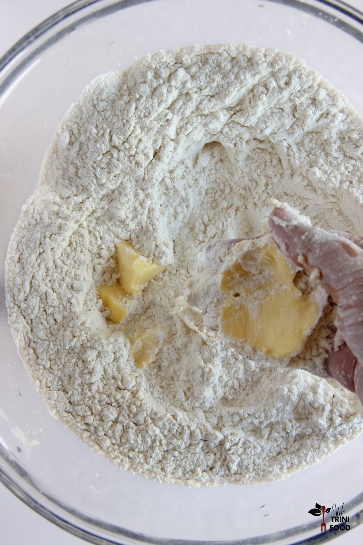 Rub butter into dry ingredients for Trini coconut bread